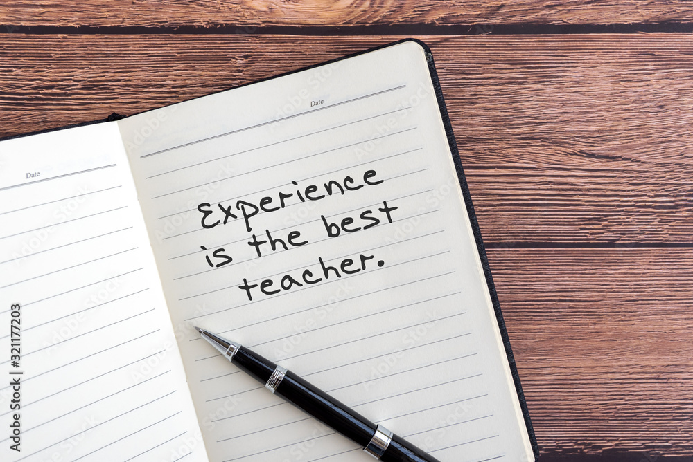 Wall mural inspirational quotes - experience is the best teacher. notepad wooden background.