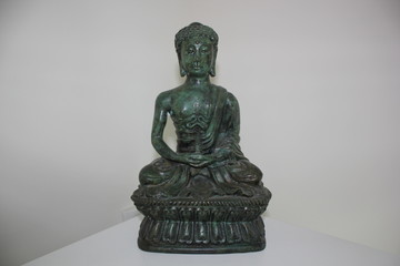 A green sitting Buddha statue.