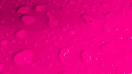 Rain drops on pink glossy surface. Water droplets background.