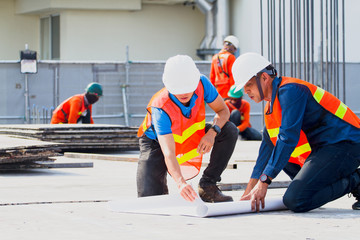The engineers clear shop drawing plan with blueprints for management business plan., consultation to discuss and solve the problem together at construction site.
