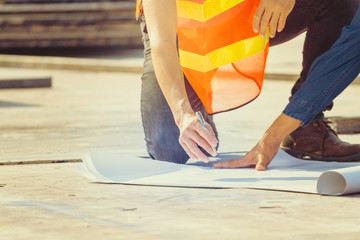 The engineers clear shop drawing plan with blueprints for management business plan., consultation to discuss and solve the problem together at construction site.