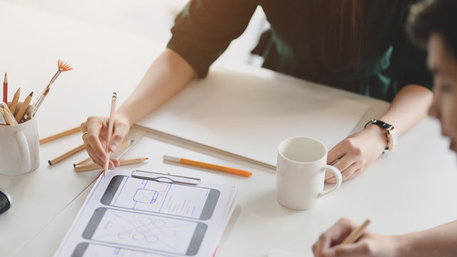 Close up view of team application developer concentrating on UI project  in meeting room
