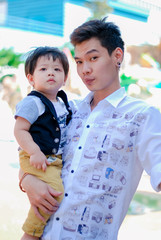 Cute little  Asian boy and father Happy smilling  in the park outdoors , Happy kids