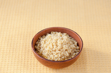 Pasta in a clay bowl on the table