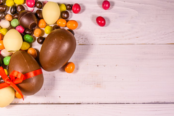 Chocolate easter eggs on a white wooden table. Top view