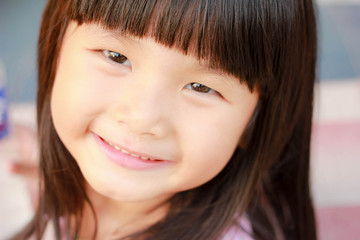 Fototapeta premium A little asian girl with a bright smile , Outdoor portrait , Thailand.
