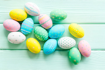 Naklejka na ściany i meble Easter eggs painted in pastel colors on green wooden background top-down