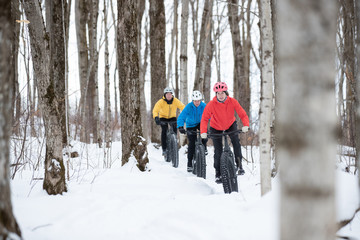 Fototapeta na wymiar Group of friends riding their fat bike in the snow in Ontario, Canada