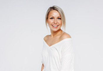 Blonde hair happy woman 35 year plus in white t-shirt and blue jeans isolated on white background