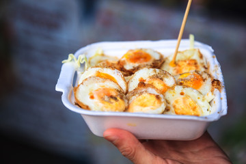 Selective Focused Cooked Quail Eggs Sprinkled with Seasoning in White Foam Box. Traditional Thai Street Comfort Food, Asian Cuisine, Delicacy, Culture, Cooking, Snack, Indulgence and Nutrition concept