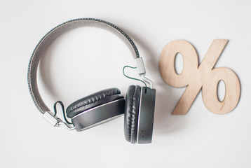 black wireless headphones with wooden sign percent. Top view photo