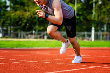 Fototapeta premium legs of sport healthy man in position of start running in the way of stadium, concentrate to the winner ahead