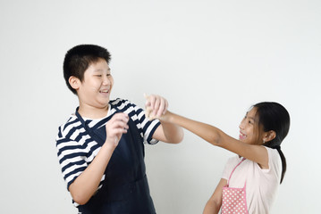 Asian preteen boy and girl preparing dough for making bread or pizza, lifestyle concept. Motion blur.