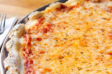 A closeup view of a rustic pizza pie in a restaurant or kitchen setting.