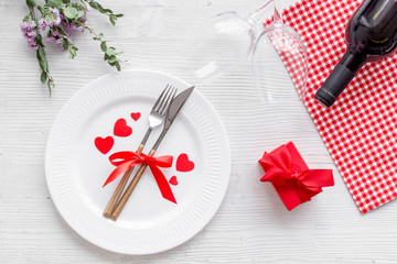 Romantic dinner on Valentines Day. Wine, plate, present box on white background top-down