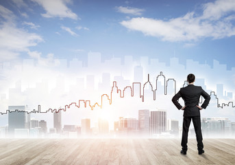 Motivation and inspiration concept with modern cityscape and businessman observing it