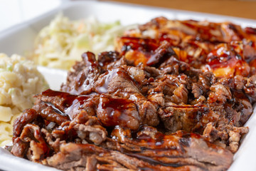 A closeup view of a container of teriyaki beef and teriyaki chicken in a restaurant or kitchen setting.