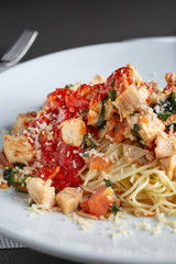 A view of a plate of chicken angel hair pasta in a restaurant or kitchen setting.