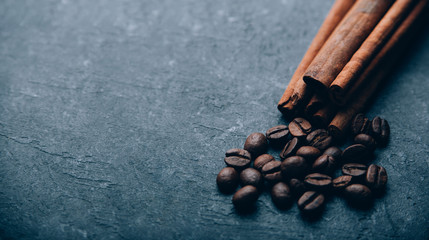 Coffee beans and cinnamon on black background