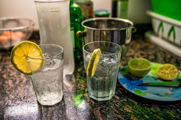 Alcoholic homemade drink (tonic cocktail tonic) with lemon and ice on marble table.