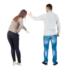 Back view of couple couple in sweater pointing.