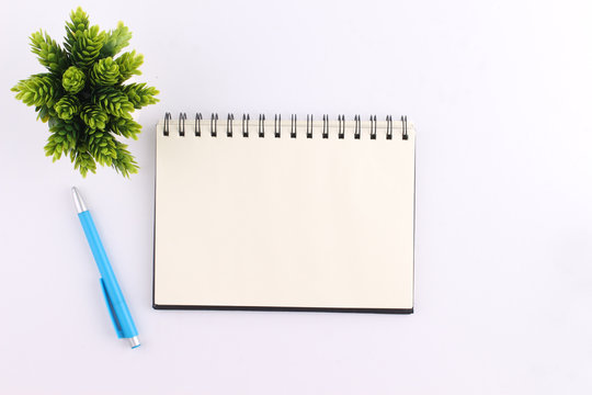 Top view blank notebook with pen on white background