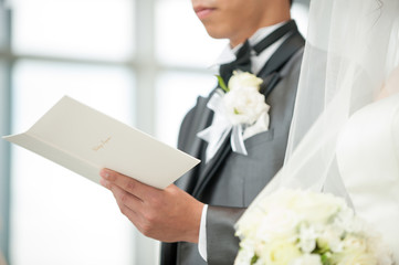 Obraz na płótnie Canvas チャペルで誓いを立てる新郎新婦　結婚式場　挙式