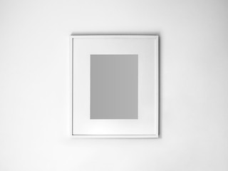 Blank white picture frame on white wall.