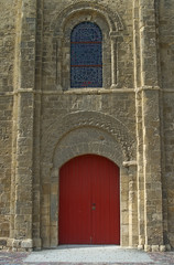 Fototapeta na wymiar View on red gate and window at gothic style catholic church entrance