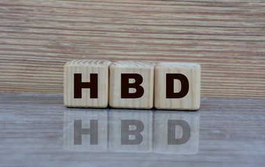 concept word HBD on cubes with a mirror image on a wooden background