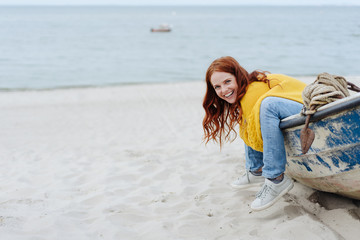 Fun loving young woman sitting in wooden dinghy