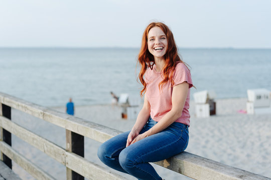 Happy vivacious young woman at the seaside