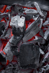 Closeup of burning charcoals in a bonfire with shallow depth of field. Abstract modern trendy texture background
