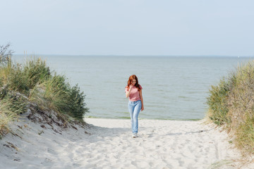Young woman walking up from a beach