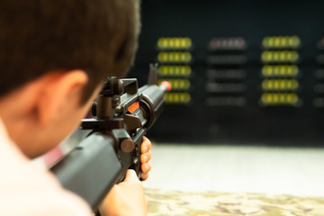 boy shooting on shooting range with air gun