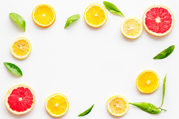 Citrus fruits - lemons, grapefruit slices - on white background mockup, frame top-down copy space