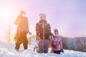 Children ride from a snow slide, have fun, play. Happy winter holidays.