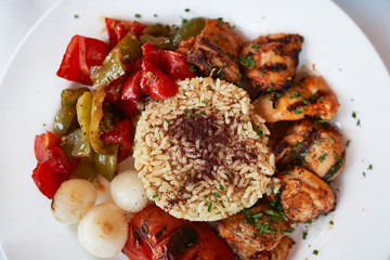 Top View of Italian Style Grilled Chicken Over Rice Served on Round Plate