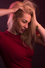 Full plus size high fashion xxl woman posing in Studio, In a red dress on a maroon background