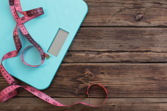 Blue Floor Scales And Pink Tape On Dark Wooden Background