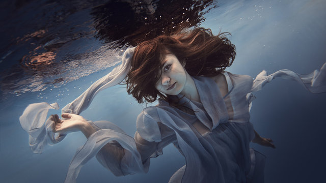 Portrait of a girl in a blue dress under water