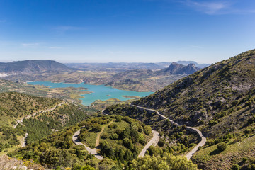 Winding road and turquoise lake in Grazalema National Park, Spain