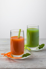 Vegetable juices, carrots and celery on a light background with mint