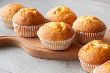 Fresh homemade delicious muffins are taken out of the oven and they cool on the kitchen table. Sweet dessert.