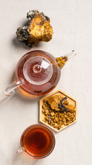 Healthy eating concept. Fashionable food drinks. Healing healthy forest mushroom tea glass mug teapot on kitchen table.