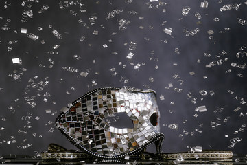 Maschera d'argento sopra la scacchiera bianca e nera con coriandoli  e cristalli