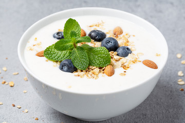 Healthy breakfast with granola, greek yogurt, blueberry and mint. Summer breakfast. 