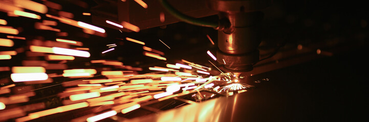 Cutting machine with rotating disc. Sparks fly out machine head for metal processing laser metal on metallurgical plant. Modern industrial technology concept. Blurred dark background