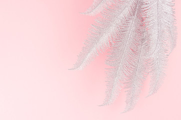Fashion festive background of silver twigs on pastel pink backdrop, top view, copy space.