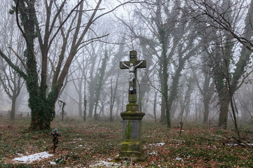 Cross in the fog in an abandoned cemetery